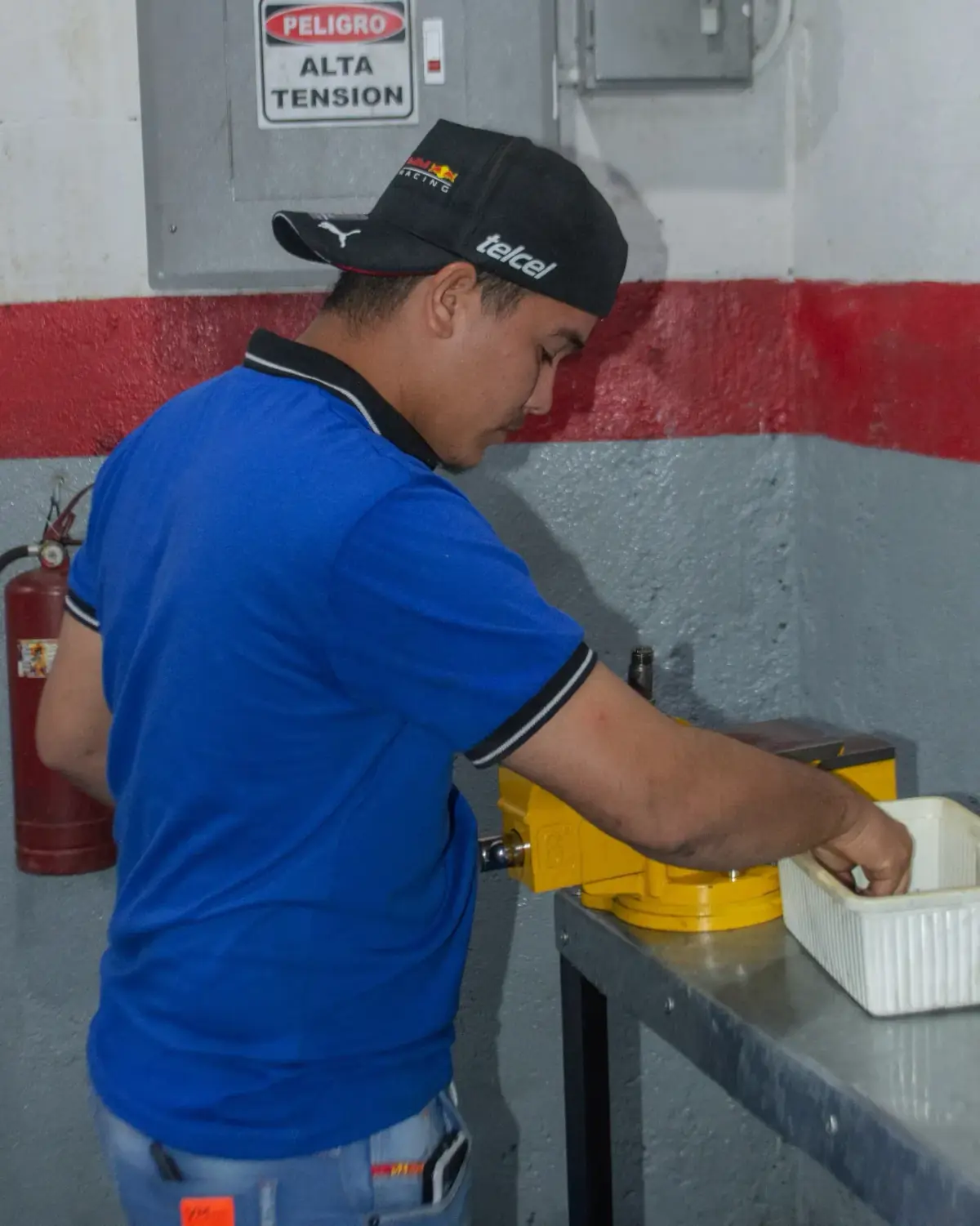 Participante limpiando piezas de inyector en la bandeja del banco