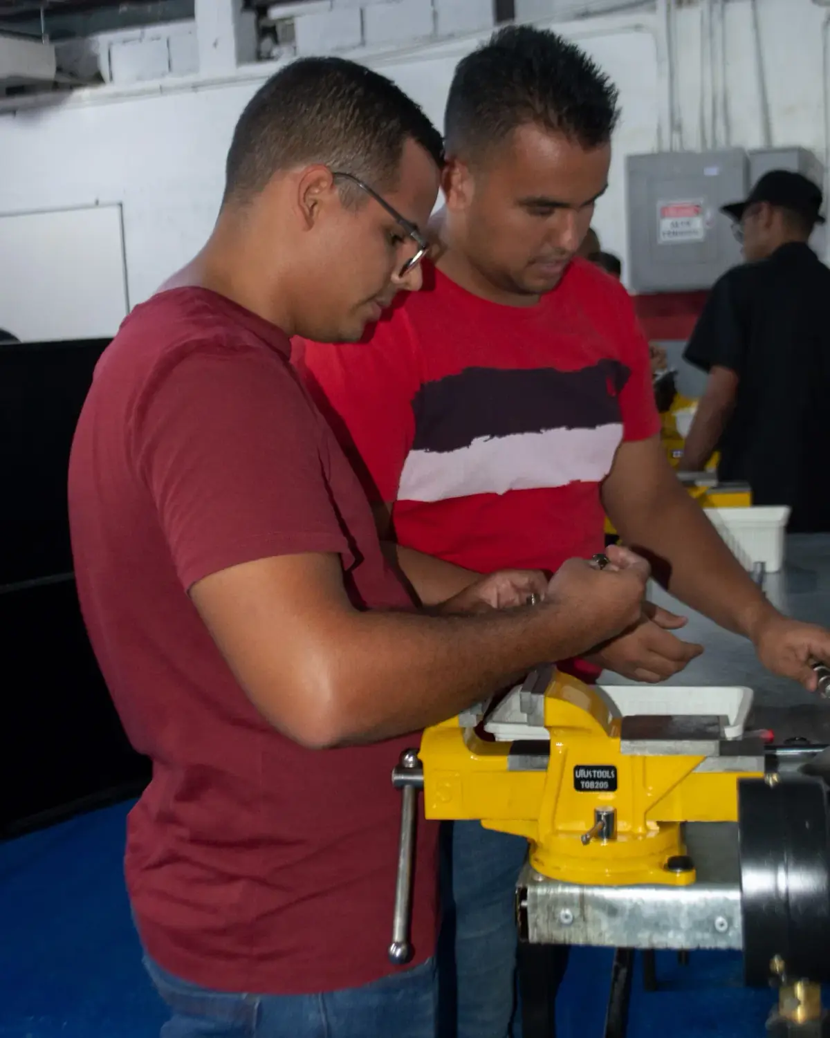 Dos participantes trabajando juntos sobre un inyector en la prensa