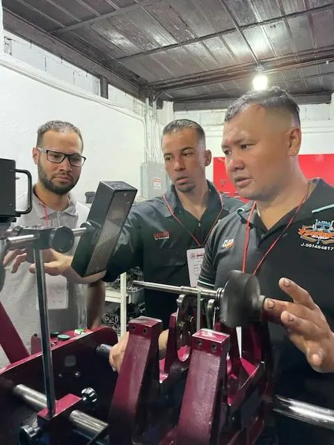 Participantes observando el trabajo sobre la máquina de balanceo