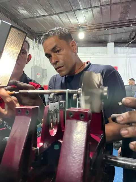 Participante trabajando el eje de un turbo en la máquina de balanceo
