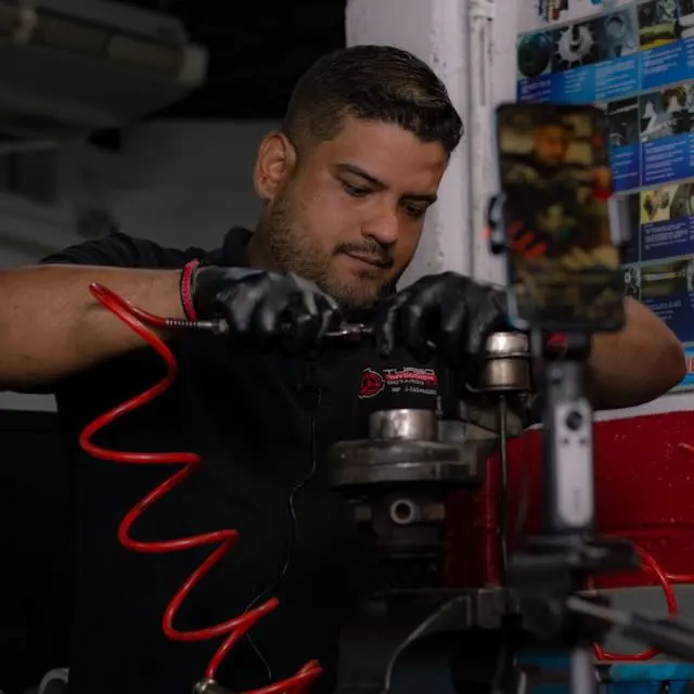 Instructor con guantes trabajando sobre un turbo mientras lo graban